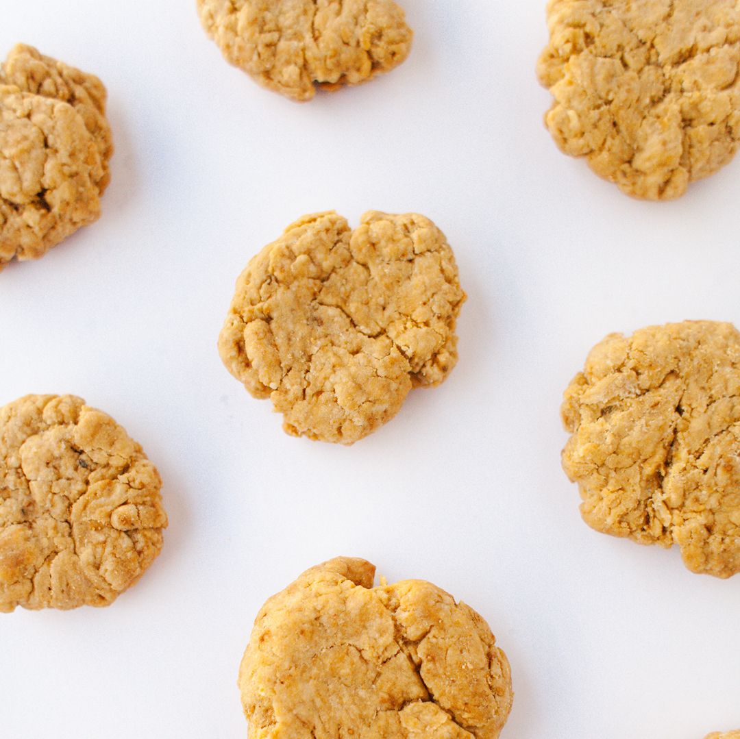 top view of seven light brown peanut butter cookies on a white background